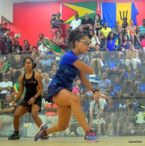 Captain Amanda Haywood (in blue) played unbeaten for the entire eight days, seen here about to blast a backhand winner in her straight games U-17 victory vs. Guyana's Rebecca Low